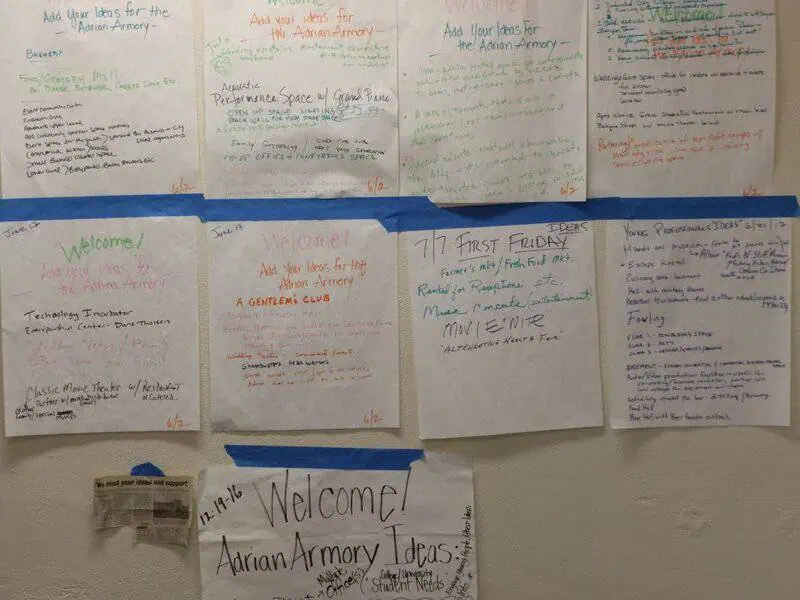 Community bulletin board showing papers with written ideas for renovations related to Adrian Armory in 2017