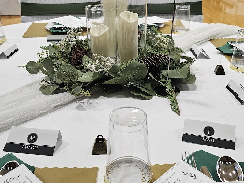 Close-up of elegant wedding table centerpiece and place settings at Adrian Armory Events Center.