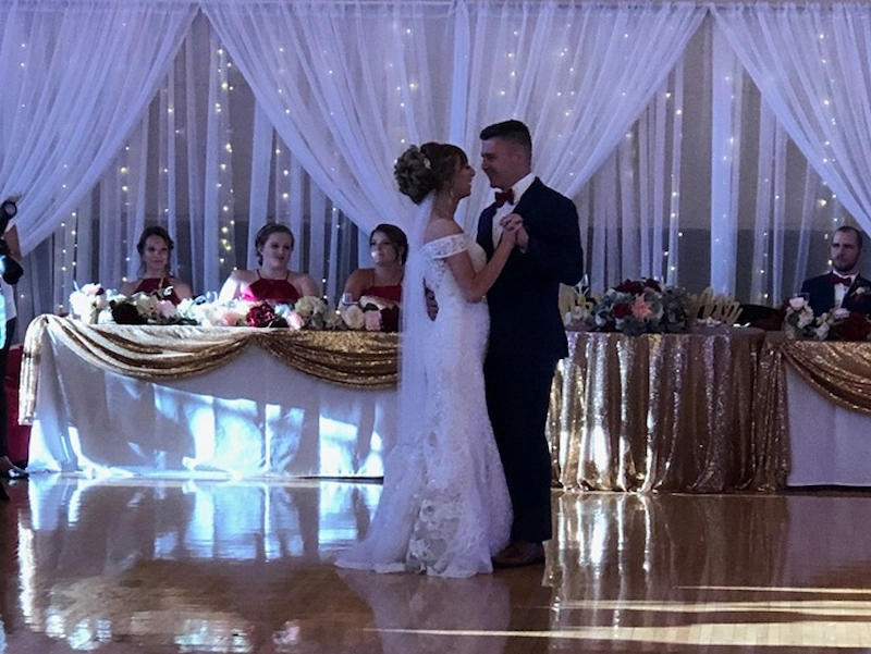 Bride and groom sharing first dance during wedding reception at Adrian Armory Events Center.