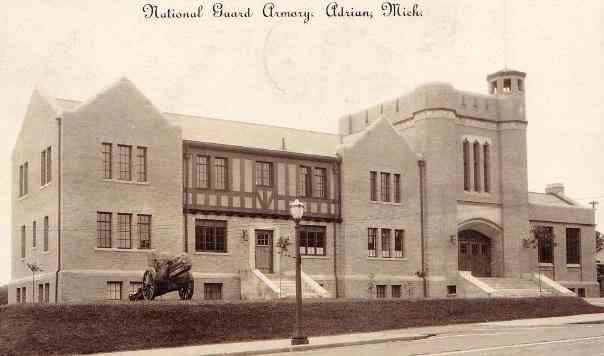 Historical photo showing outside view of the Adrian Armory with cannon in front