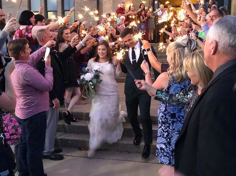 Newlyweds exiting Adrian Armory through sparkler send-off at wedding celebration.