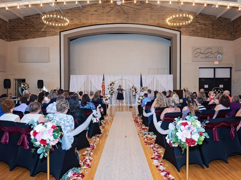 Wedding ceremony setup with aisle décor inside Adrian Armory Events Center.